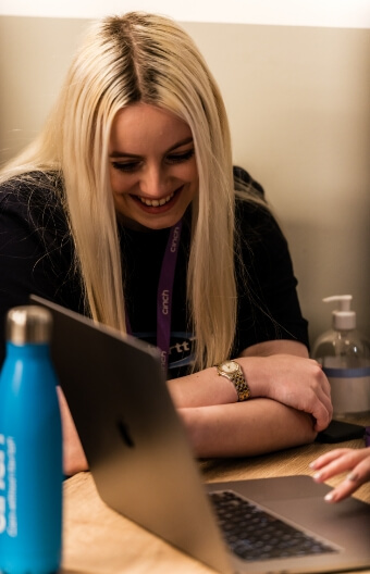 A woman looking at a laptop and smiling