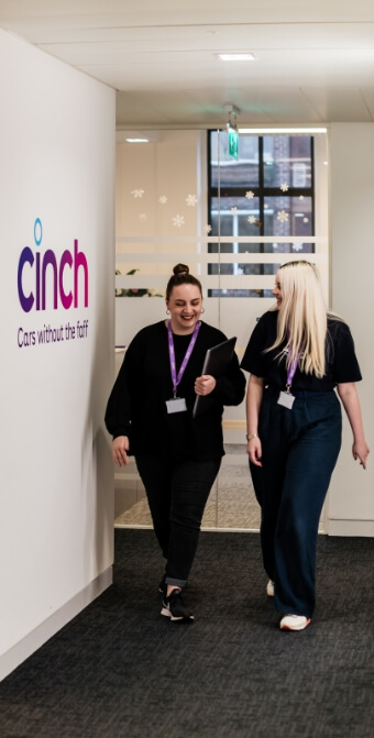 Two women walking down a corridor in the cinch office