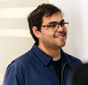 A man standing in an office and smiling