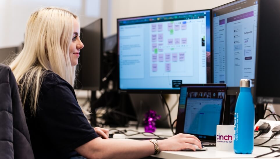 A woman sat working at a desk using a computer