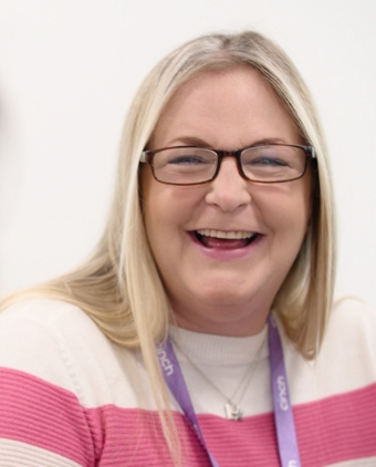 A smiling woman wearing a cinch lanyard