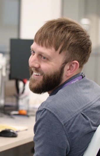A smiling man in the cinch office wearing a cinch branded lanyard