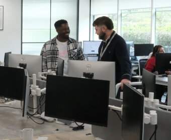 Two people standing and talking in the cinch office