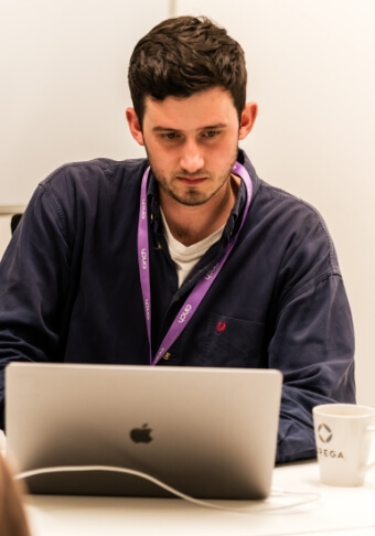 A man wearing a cinch lanyard and using a laptop